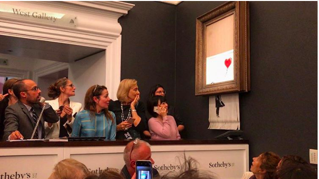 yllättyneet katsojat reagoivat, kun Banksyn tyttö ilmapallolla tuhoaa itsensä Sotheby ' sissa.'s Girl With a Balloon self-destructs at Sotheby's.