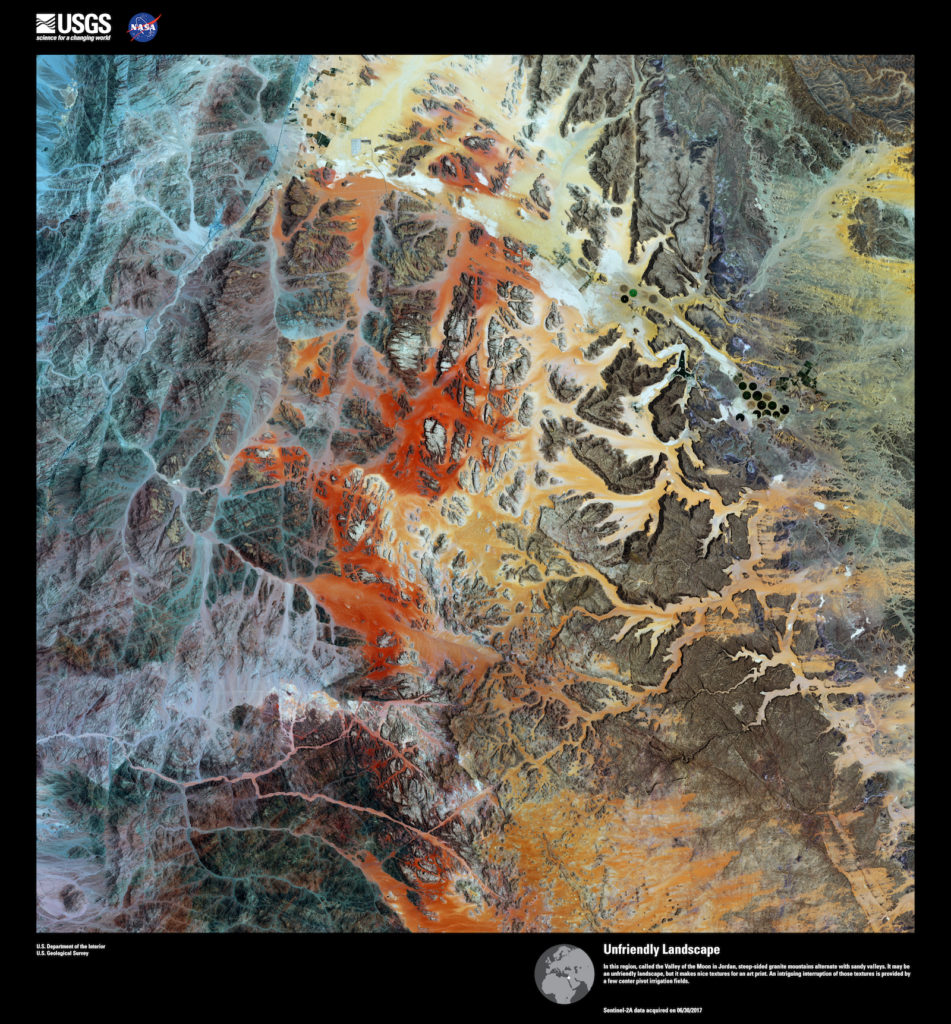 Landsat 8, <em>Unfriendly Landscape</em>. In this region, called the Valley of the Moon in Jordan, steep-sided granite mountains alternate with sandy valleys. It may be an unfriendly landscape, but it makes nice textures for an art print. An intriguing interruption of those textures is provided by a few center pivot irrigation fields. Image courtesy of US Geological Survey/NASA.