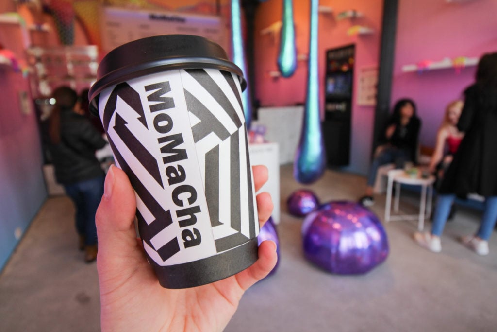The original MoMaCha logo as seen here on a coffee cup was very similar to the MoMA logo as it appears in the museum's banner.