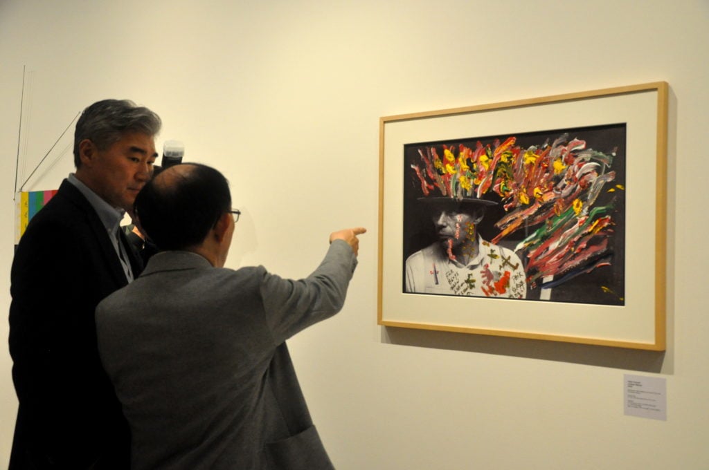 The US Ambassador to the Philippines, H.E. Sung Kim [left], discussing a Nam June Paik mixed media portrait of Joseph Beuys with Mr. Ken Hakuta (right), Courtesy of León Gallery International.
