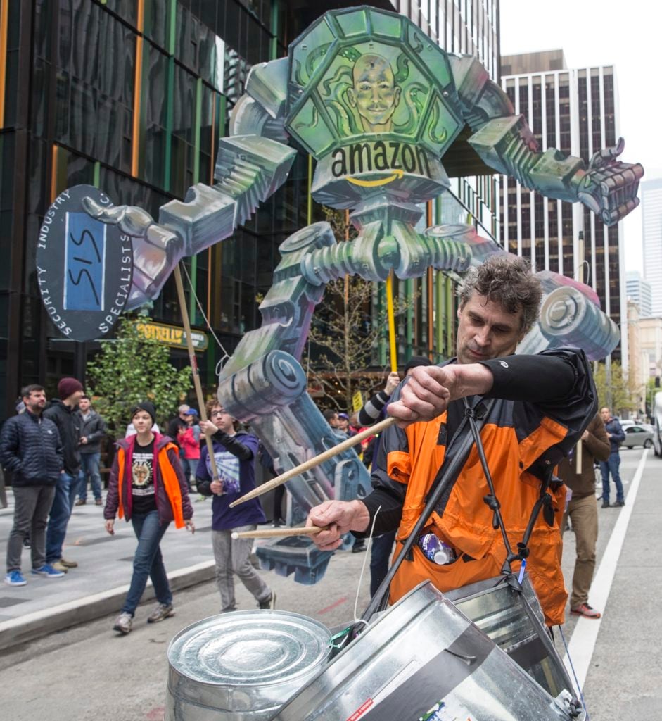 A drummer takes part in a protest in front of a Amazon.com CEO Jeff Bezos effigy outside of the Amazon.com headquarters on May 1, 2017 in Seattle. Hundreds took part in the annual May Day event. Photo by Stephen Brashear/Getty Images.