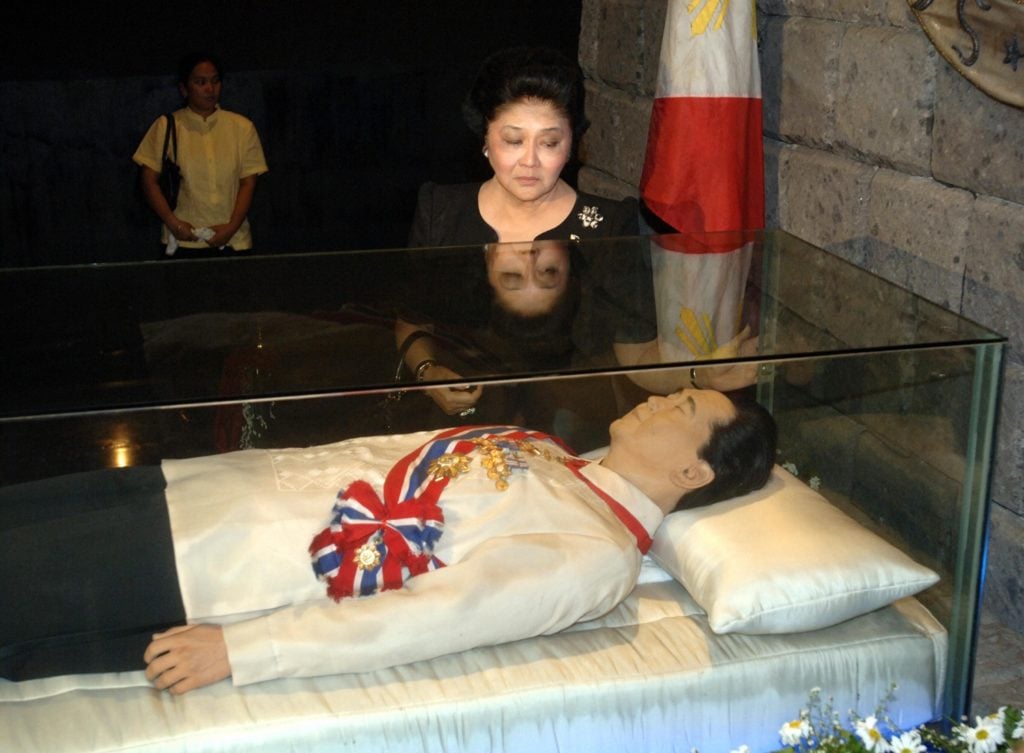 Former Philippine first lady Imelda Marcos pays her respects to a glass enclosure holding the preserved body of thelate Philippines president Ferdinand Marcos 11 September 2005 marking his 88th birthday in Batac, Ilocos norte, northern Philippines. Photo courtesy Jay Directo/AFP/Getty Images.