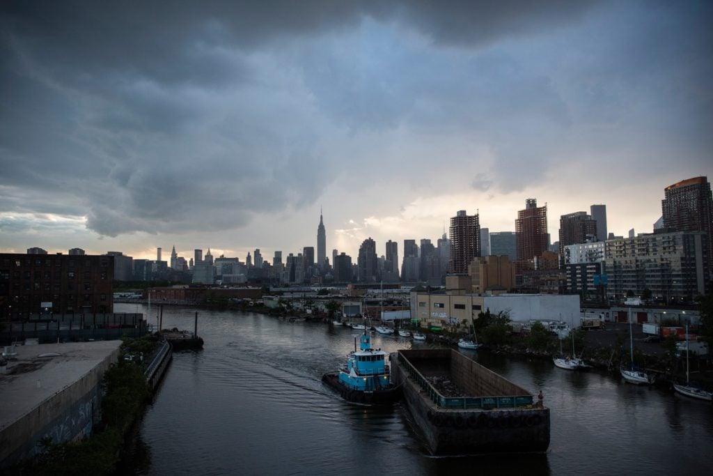 A tugboat and barge move up Newtown Creek. Photo by Andrew Burton/Getty Images.