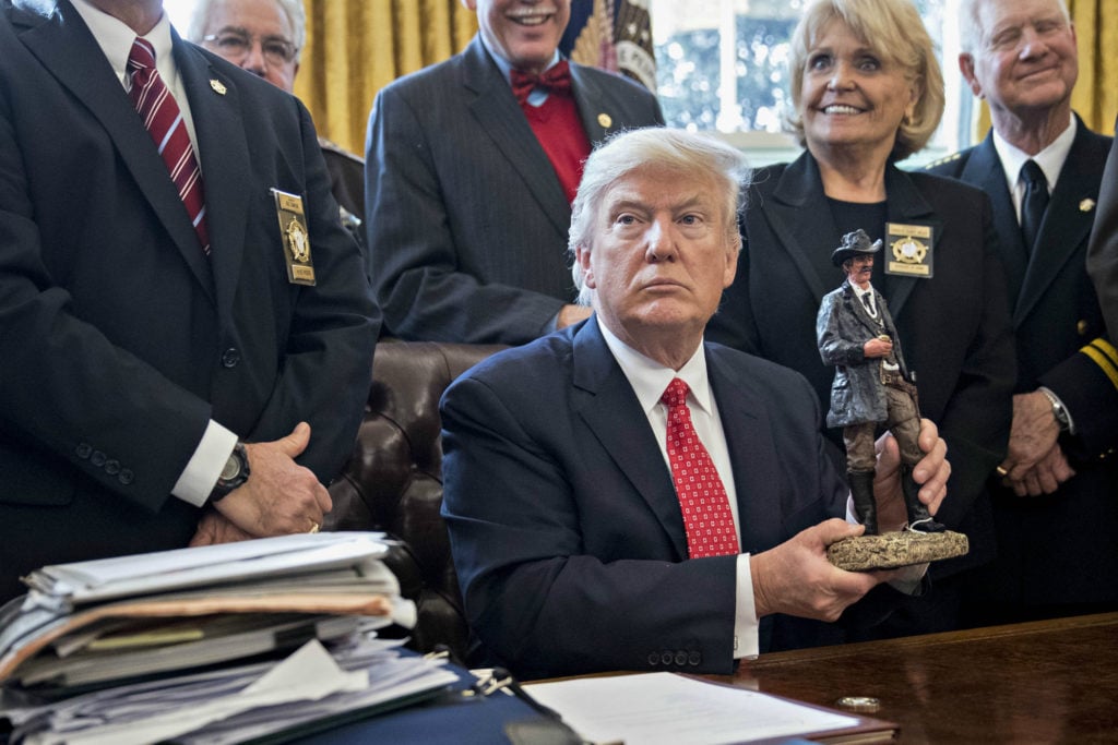US President Donald Trump admires a statue he received as a gift from county sheriffs, February 7, 2017. Photo by Andrew Harrer- Pool/Getty Images.