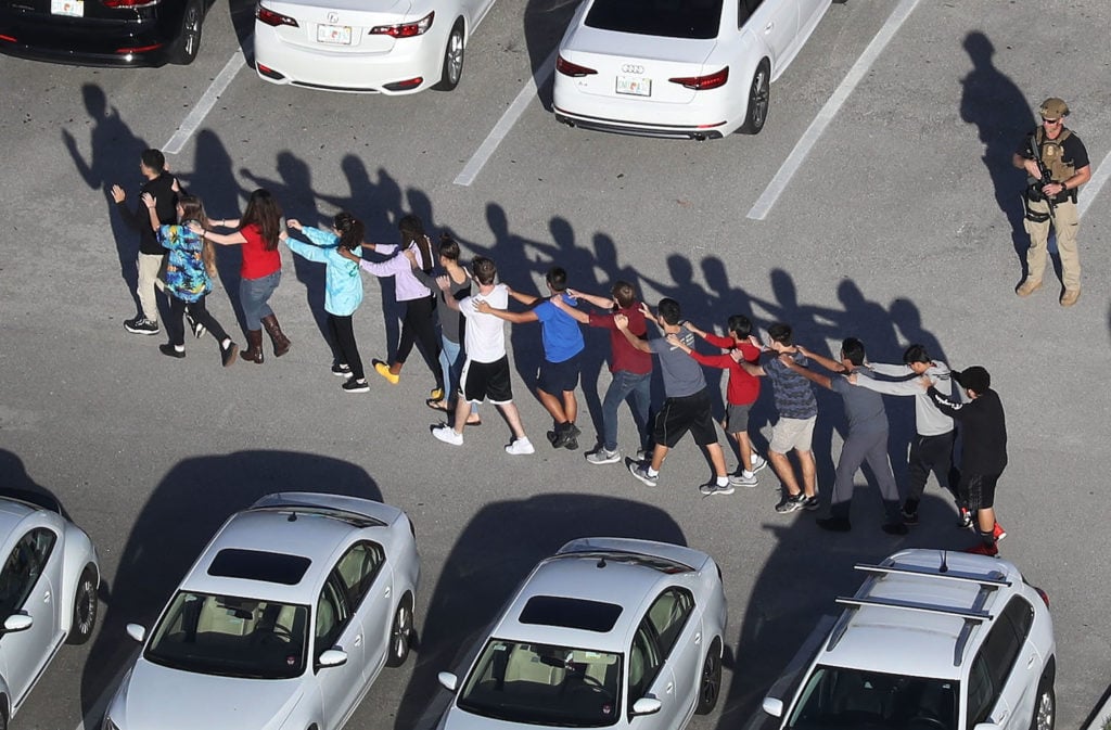 People are brought out of the Marjory Stoneman Douglas High School after a shooting at the school that reportedly killed and injured multiple people on February 14, 2018 in Parkland, Florida. Photo by Joe Raedle/Getty Images.