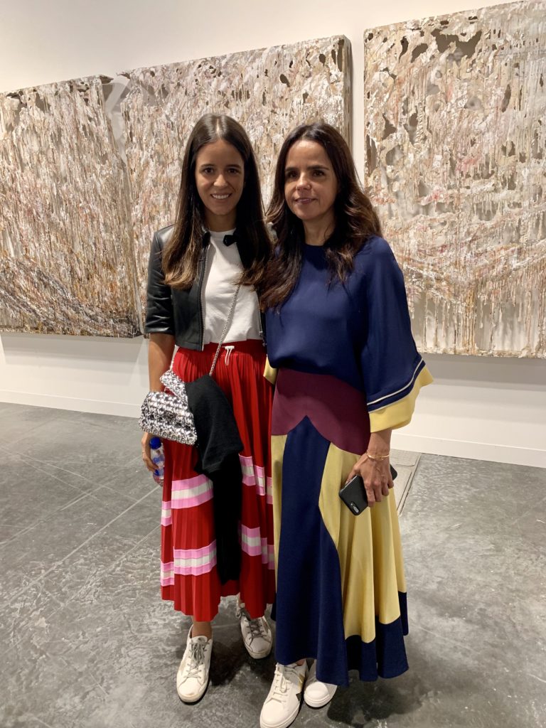 Julia Brito and Luciana Brito with a work by Diana Al Hadid from Marianne Boesky Gallery at Art Basel Miami Beach. Photo by Sarah Cascone.
