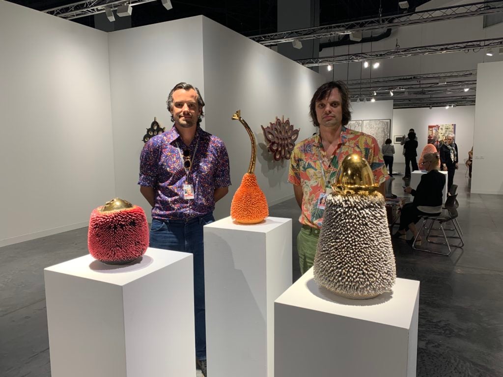 Simon Haas and Nikolai Hass, known collectively as the Haas Brothers, with their ceramic accretions works at Marianne Boesky's booth at Art Basel in Miami Beach. Photo by Sarah Cascone. 