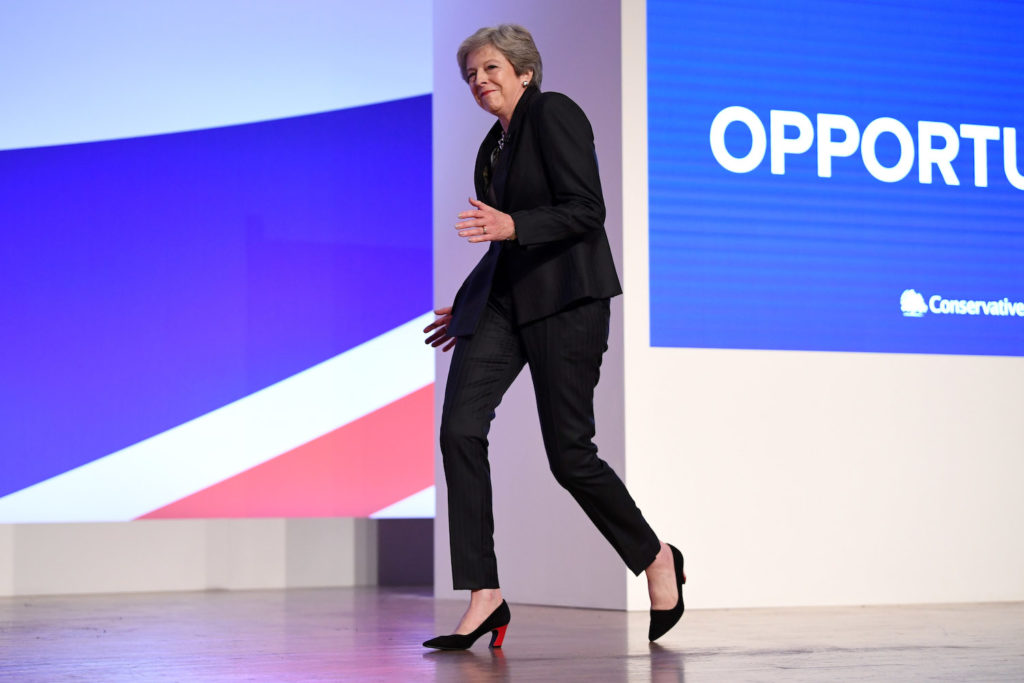 British Prime Minister Theresa May dances as she walks out onto the stage to deliver her leader's speech during the final day of the Conservative Party Conference at the International Convention Centre on October 3, 2018 in Birmingham, England. Photo by Jeff J Mitchell/Getty Images.