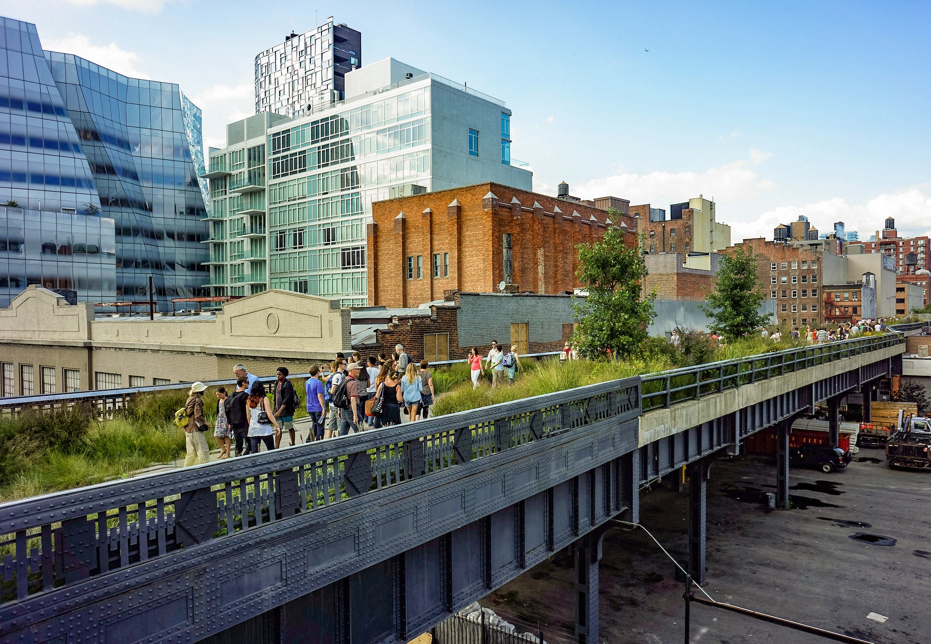 Visitors stroll the first section of the High Line Park, over the 18th Street crossing, in 2012. Frank Gehry's IAC building is in the background. Photo by Dansnguyen, Creative Commons CC0 1.0 Universal Public Domain Dedication.