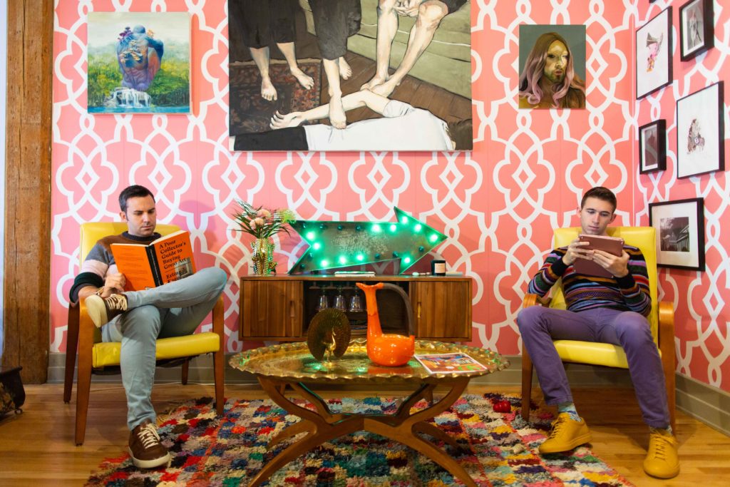 Alex Mitow (left) and James Miille, in their Brooklyn apartment, with works by Mark Liam Smith, Thomas Bils, and Nadav Gazit behind them. Photo: James Miille.