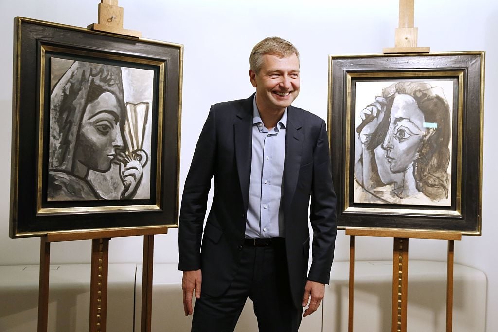 Russian businessperson Dmitry Rybolovlev poses in Paris on September 24, 2015 in front of two allegedly stolen paintings by Pablo Picasso, <am>Espagnole a l'Eventail</em> (left) and <em>Femme se Coiffant</em>, which he purchased from Swiss art dealer Yves Bouvier. Image courtesy AFP Photo/Patrick Kovarik.