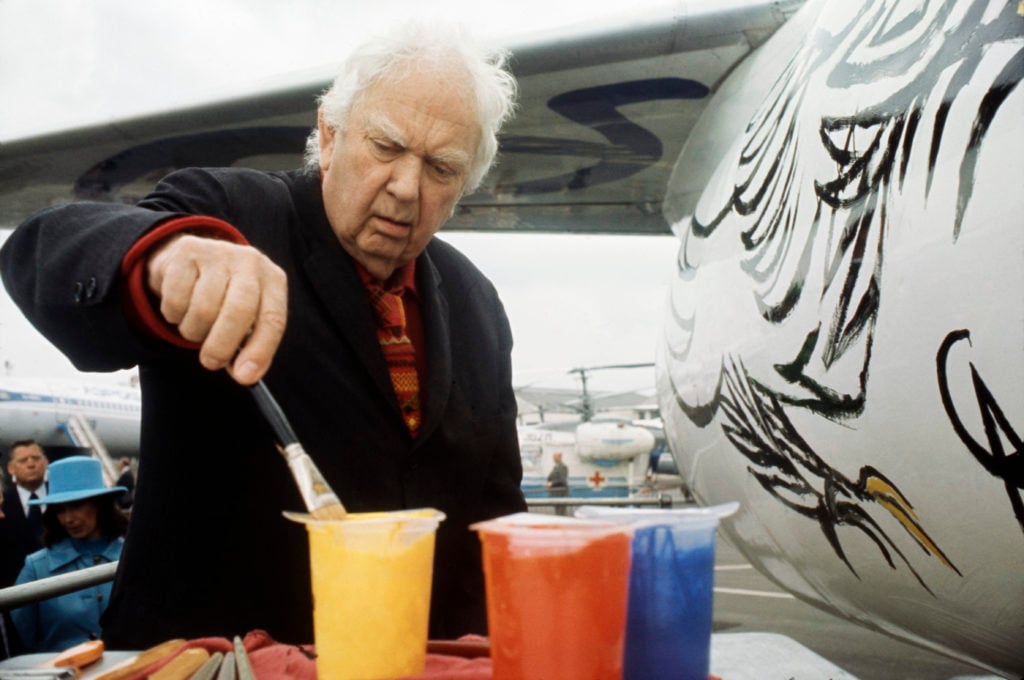Alexander Calder paints the fuselage of a Boeing 727-291 passenger plane as a commission from Braniff International Airways, Dallas, Texas, 1975. Photo by Camerique/Getty Images.