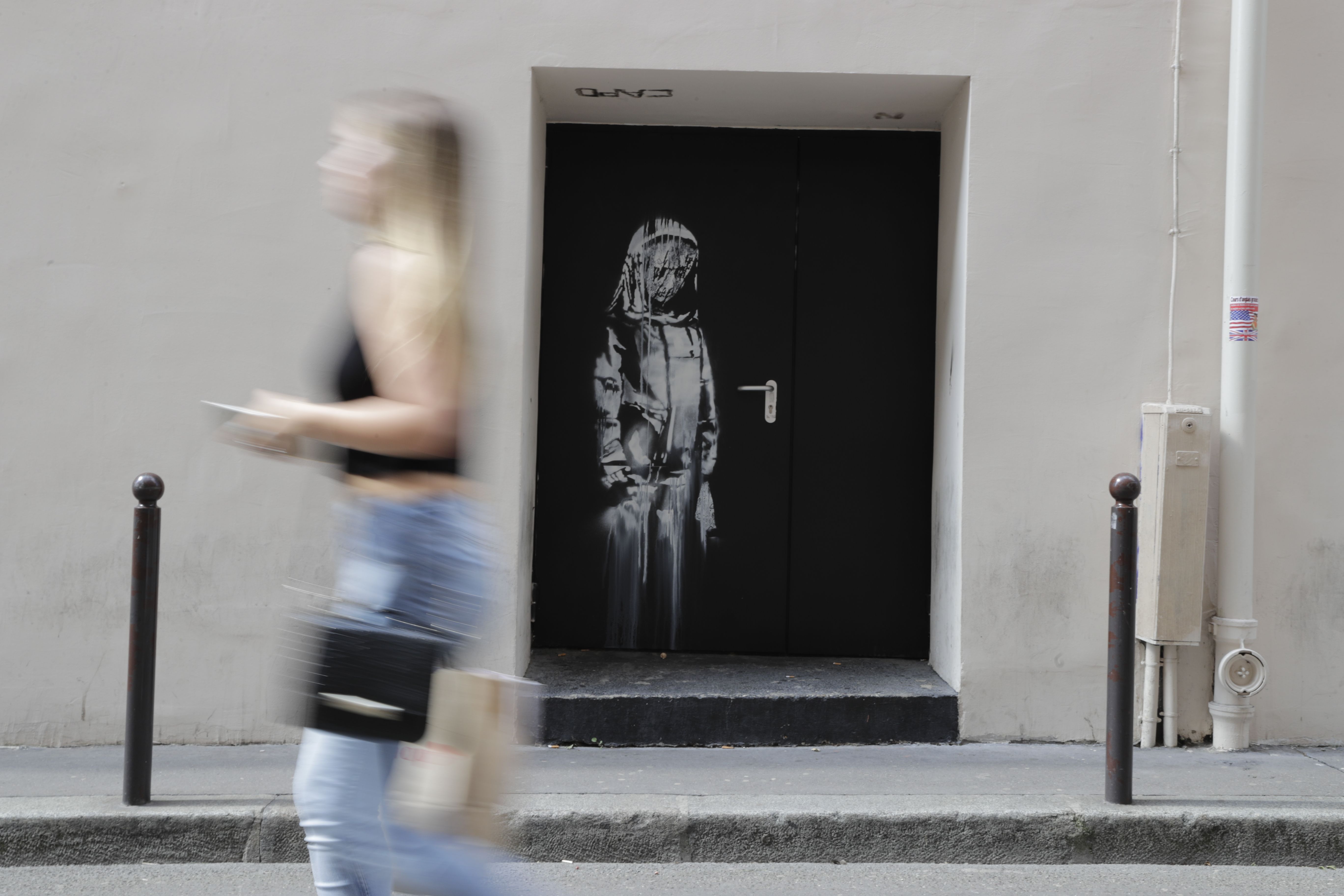 Banksy's mural in Paris where a terrorist attack killed 90 people on Novembre 13, 2015. Photo: Thomas Samson/AFP/Getty Images.