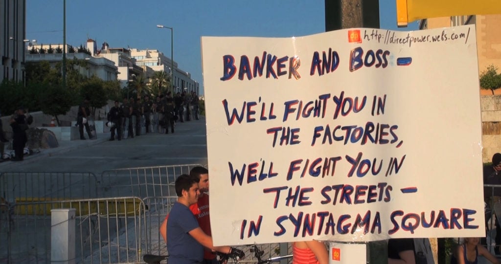 A protest sign in Greece. Image courtesy Zeitgeist Films.