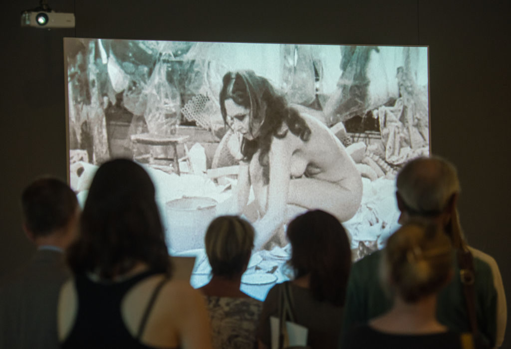 A group of people looks at the artwork 'Body Collage' by Carolee Schneemann from 1967 at the exhibition 'Carolee Schneemann. Kinetische Malerei' in Frankfurt/Main, Germany, 30 May 2017. Photo by Andreas Arnold/picture alliance via Getty Images.