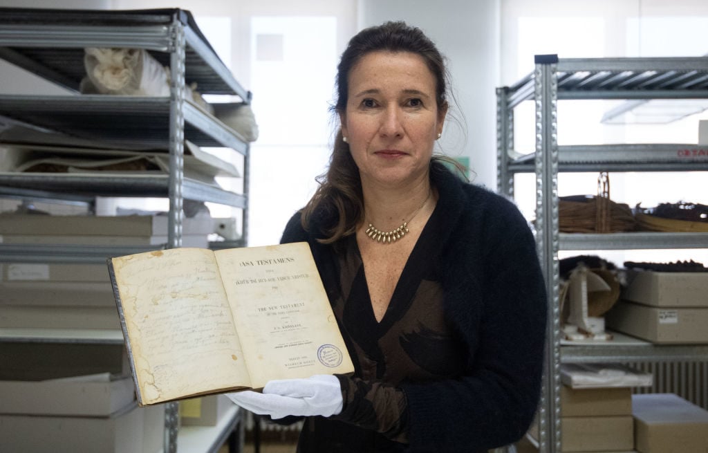 Inés de Castro, director of the Linden Museum, holds a Bible by the Namibian national hero Hendrik Witbooi. The German state of Baden-Württemberg wants to return two stolen colonial goods to Namibia. Photo: Marijan Murat/Picture Alliance/Getty Images.