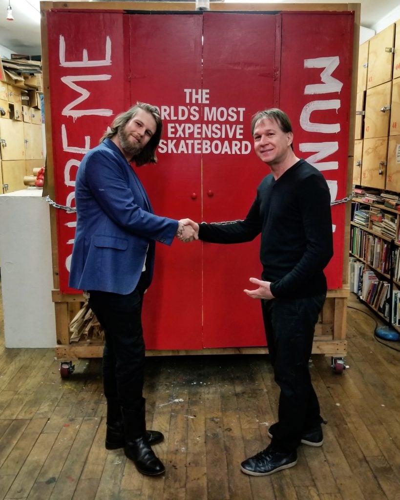 Jon Satin collecting the <em>Supreme Mundi</em> from Brandon Wisecarver, gallery managing director at Con Artist Gallery. Photo courtesy of Con Artist Gallery.