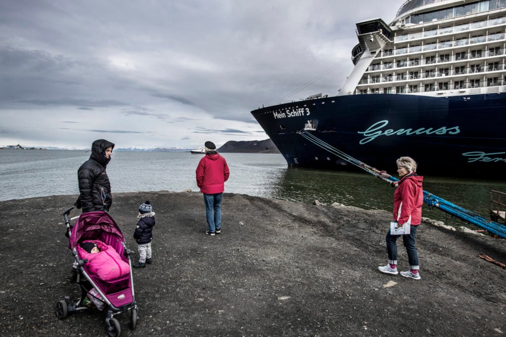 Longyearbyen, Svalbard Islands, Norway, July 2018. © Kadir van Lohuizen – NOOR for Fondation Carmignac. The archipelago and its main island, Spitzbergen, are under the Norwegian sovereignty. Their population of 2,500 more than doubles when a 300 m-long cruise ship like the Mein Schiff 3 (“My Ship 3”) disembarks its 3,000 passengers and 1,000 crew members.