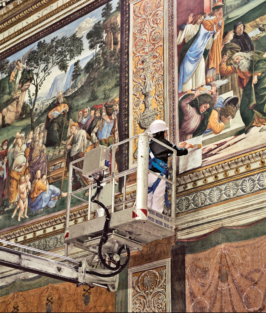 A master conservator demonstrating a technique for removing contaminants from a Botticelli fresco in the Sistine Chapel. Photo by Robert Polidori for <em>WSJ Magazine</em>.