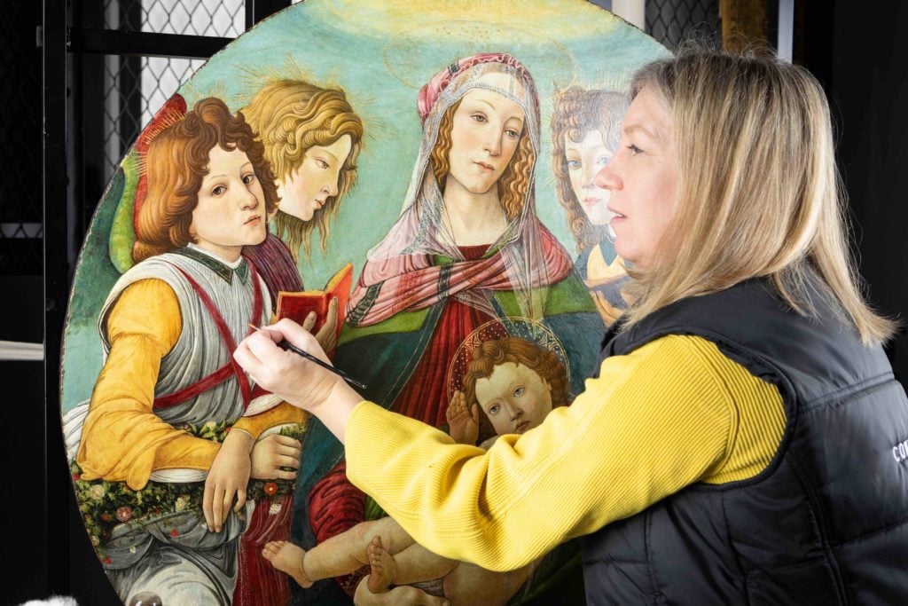 English Heritage Conservator Rachel Turnbull completes the conservation of Madonna of the Pomegranate, a painting revealed today as a rare example by the workshop of Botticelli. ©English Heritage.