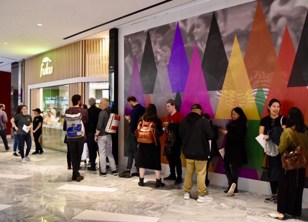 Shoppers wait in line for Fuku in front of Rico Gatson's <em>Hidden in Plain Sight</em>. Image courtesy Ben Davis.