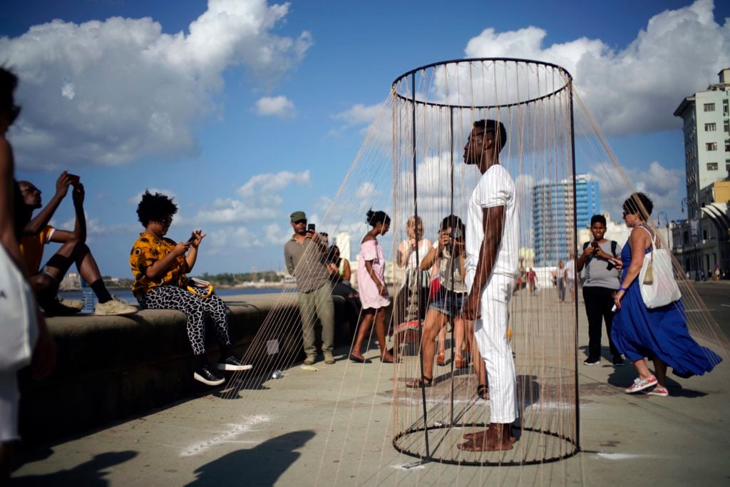 Cuban-American artist Carlos Martiel stands inside his art project The Blood of Cain at the Malecon waterfront during the 13th Havana Biennial art fair, on April 14, 2019, in Havana, Cuba. Photo: Sven Creutzmann/Mambo photo/Getty Images.