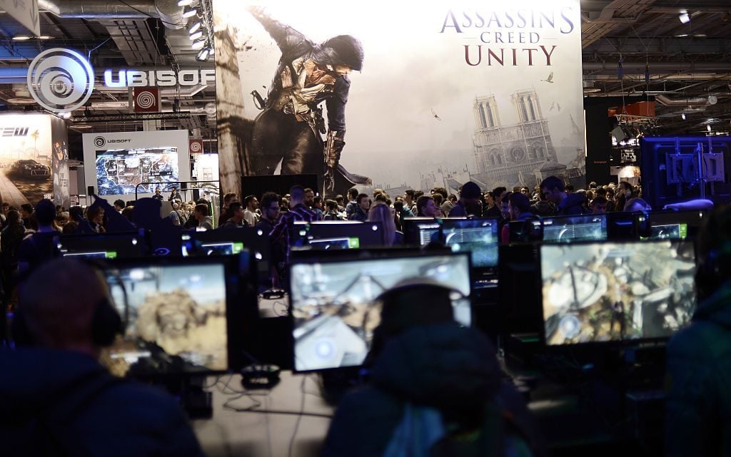 Visitors stand at a booth for the computer game Assassins Creed Unity in 2014 in Paris. Photo by Stephane de Sakutin/AFP/Getty Images.