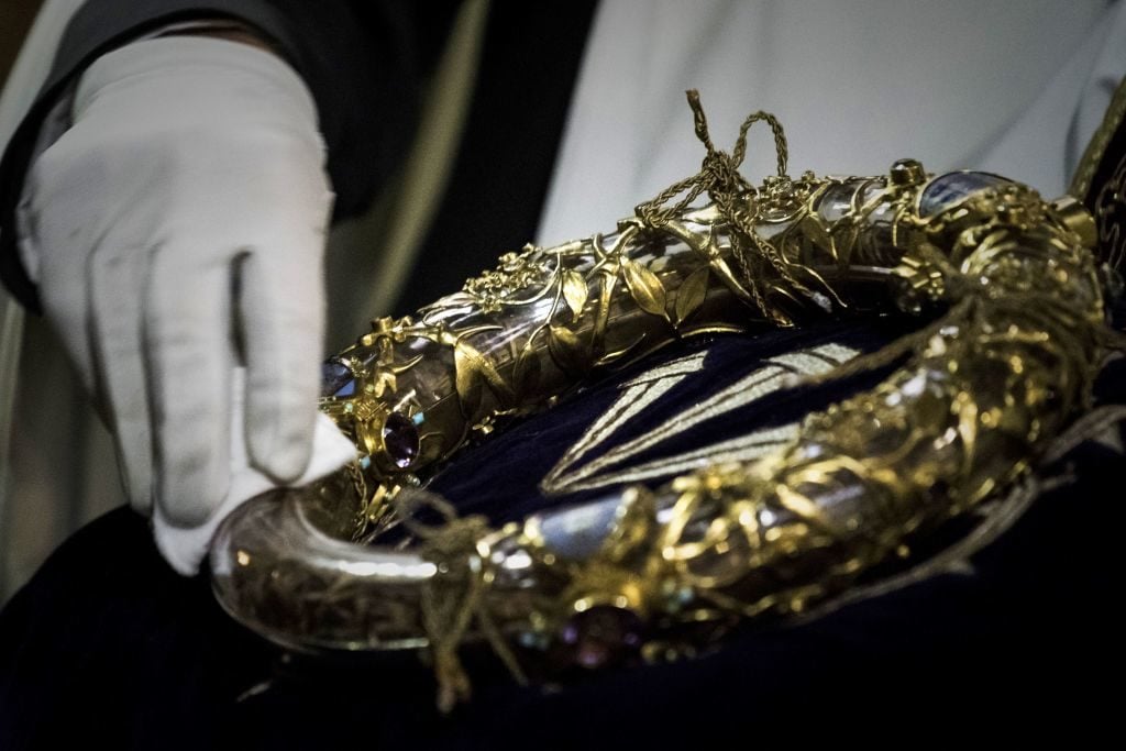 A priest wipes the Crown of Thorns, a relic of the passion of Christ- at the Notre-Dame Cathedral in Paris on April 14, 2017. Photo by Philippe Lopez/AFP/Getty Images.