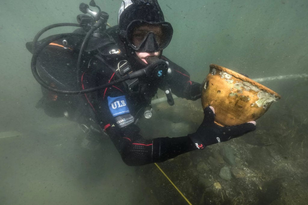 A marine archaeologist recovering an artifact from the archaeological site at Lake Titicaca. Photo by Teddy Seguin