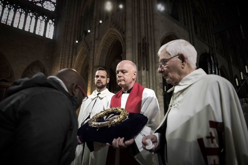 A priest holds the Crown of Thorns as the relic of the passion of Christ is presented to faithfuls at the Notre Dame Cathedral in Paris on April 14, 2017. Photo courtesy Philippe Lopez/AFP/Getty Images.