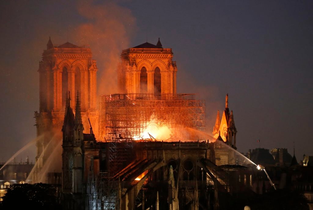 Flames and smoke are seen billowing from the roof at Notre Dame Cathedral on April 15, 2019 in Paris, France. Photo by Chesnot/Getty Images.