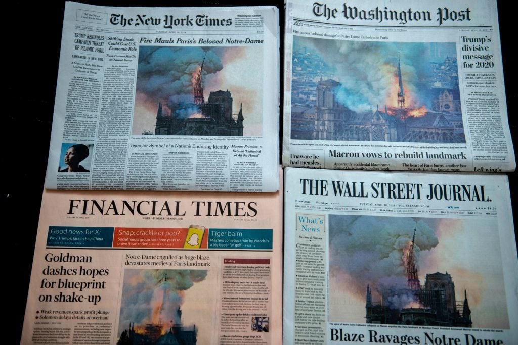 Editions of the New York Times, The Washington Post, The Wall Street Journal and the Financial Times display images of Notre-Dame Cathedral burning in Paris on their front page on April 16, 2019 in Washington DC. Photo courtesy Eric Baradat/AFP/Getty Images.