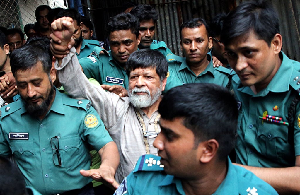 Shahidul Alam waves to people after police take him to a Dhaka metropolitan magistrate's court on January 13, 2019. Photo by Sony Ramany/NurPhoto via Getty Images.