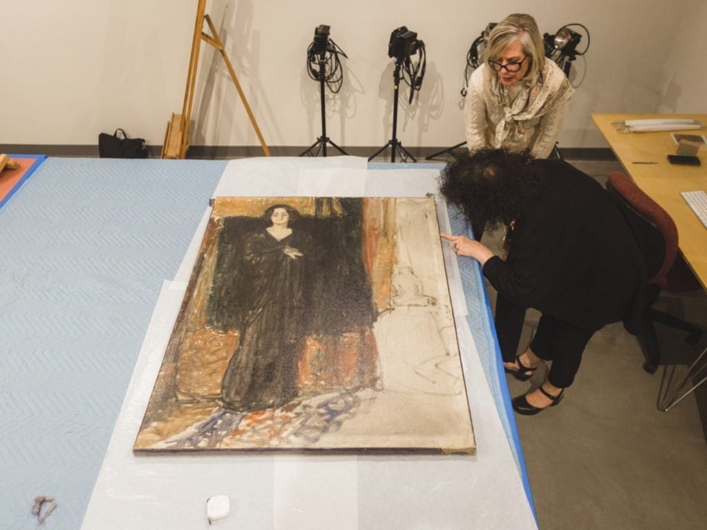Specialists from the Flaten Art Museum and the Scientific Analysis of Fine Art examined the canvas edge of <em>Portrait of Eva Mudocci</em> attributed to Edvard Munch. Photo by Will Cipos for the Flaten Museum of Art art St. Olaf's College. 