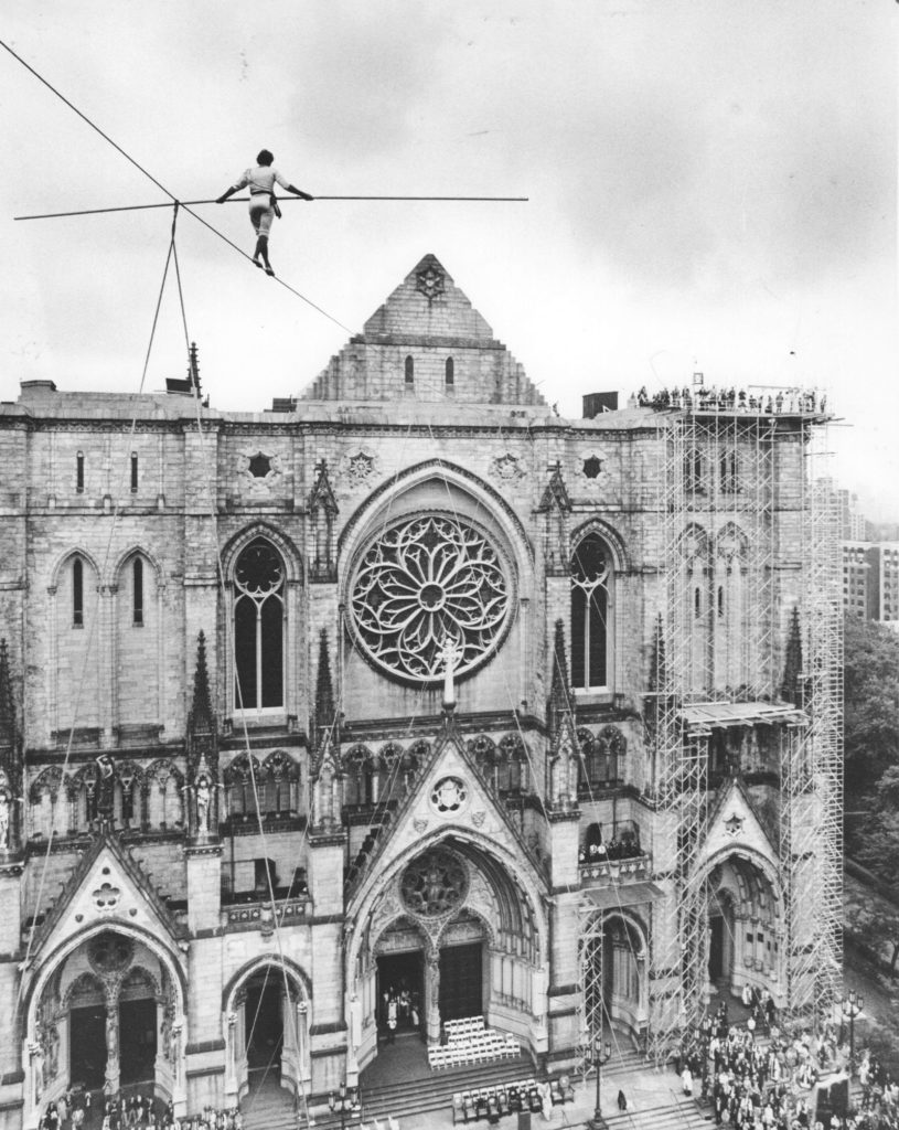 Phillippe Petit balances on a wire over Amsterdam Avenue in Manhattan, New York as he walks towards the Cathedral of St. John the Divine on September 29, 1982. Photo by Joe Dombroski/Newsday via Getty Images.
