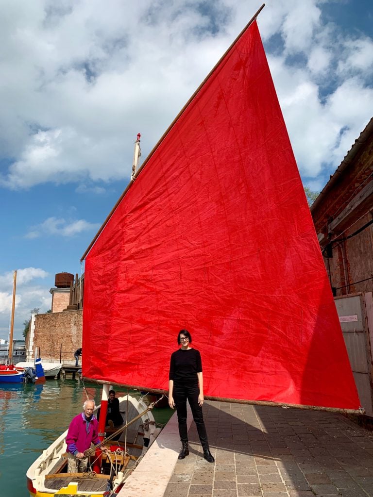 Melissa McGill with one of the boats for her project Red Regatta. Photo by Sarah Cascone.