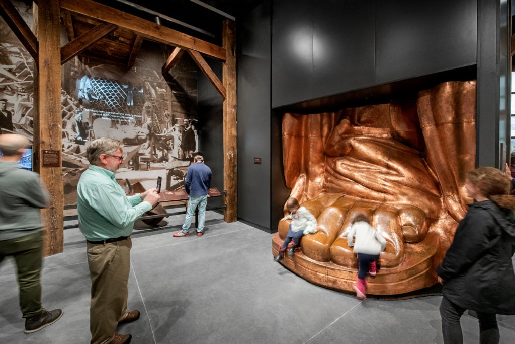 Visitors are encouraged to touch the full-scale replica of Liberty's foot. Photo © Keena Photo.