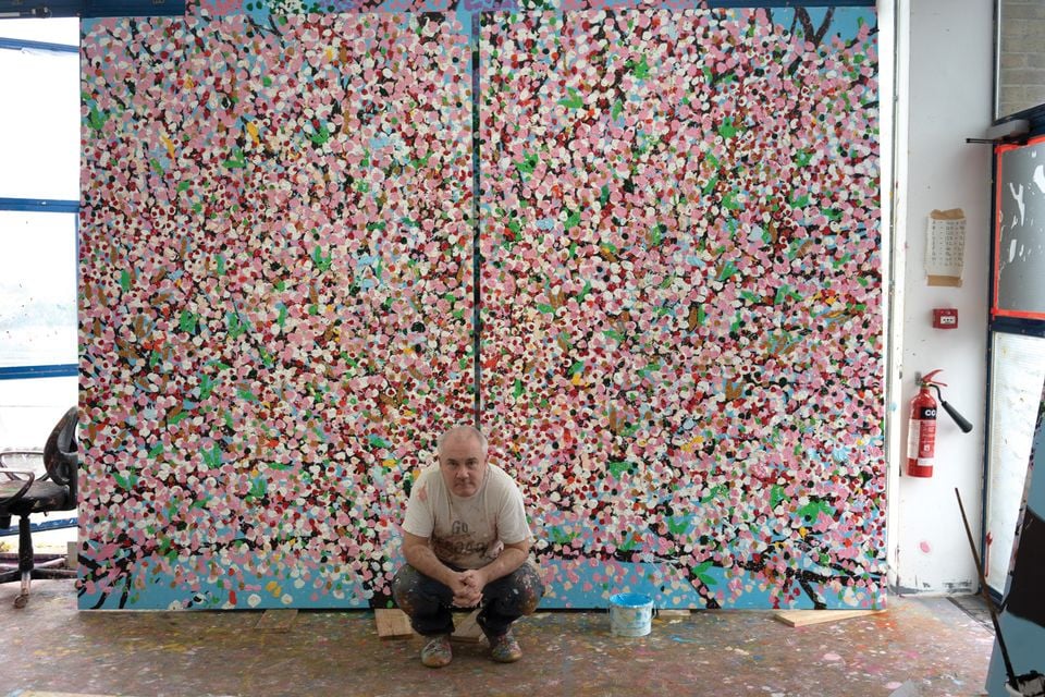 Damien Hirst with one of his new cherry blossom paintings. Photo by Prudence Cummings Associates ©Damien Hirst and Science Ltd.