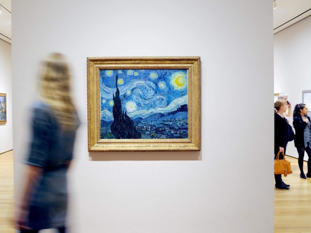 Visitors in the galleries at the Museum of Modern Art with Vincent van Gogh's <em>The Starry Night</em> (1889). Photo by Martin Seck, ©2017 the Museum of Modern Art. 