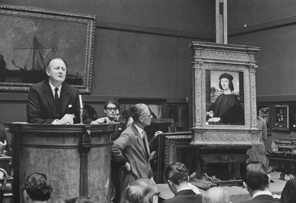 Sotheby's Chairman and chief auctioneer Peter Wilson (1913-1984) conducts a sale of Renaissance paintings at Sotheby's auction house in London on 28th November 1963. The painting on the right is 'Portrait Of A Young Man In Red', by Raphael. (Photo by Les Lee/Daily Express/Hulton Archive/Getty Images)