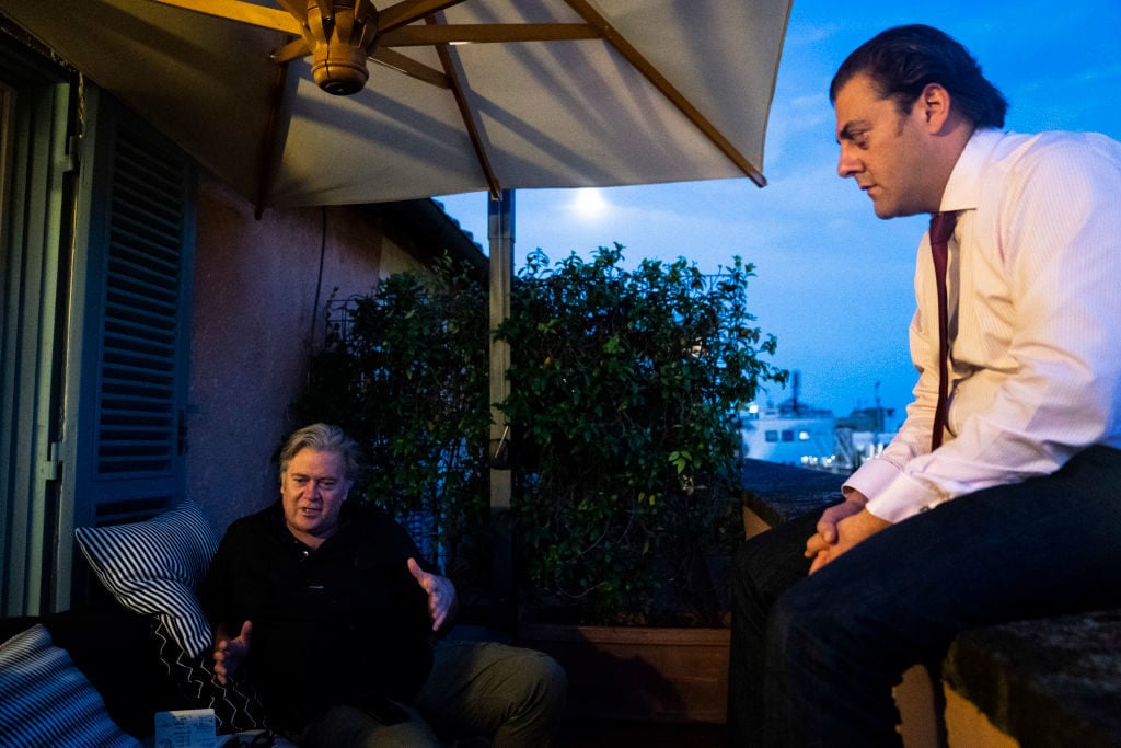 Benjamin Harnwell, right, listens as former White House Chief Strategist Steve Bannon, speaks with a reporter on his terrace at Hotel de Russie on Friday, Sept 21, 2018 in Rome, Italy. Photo: Jabin Botsford/The Washington Post via Getty Images.
