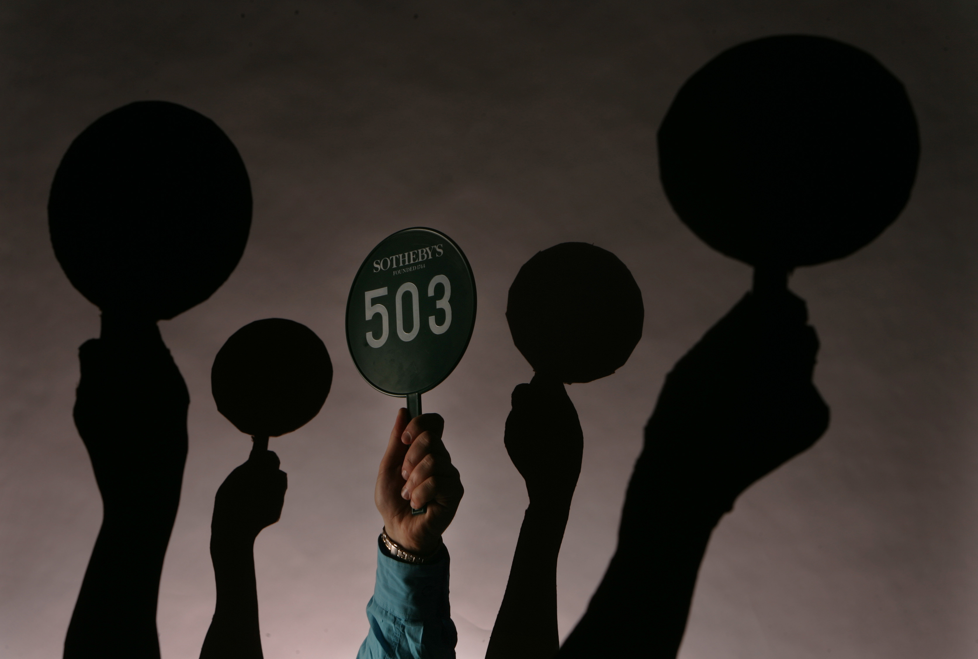 An auction paddle in action illustration. Photo by Steve Russell/Toronto Star via Getty Images.