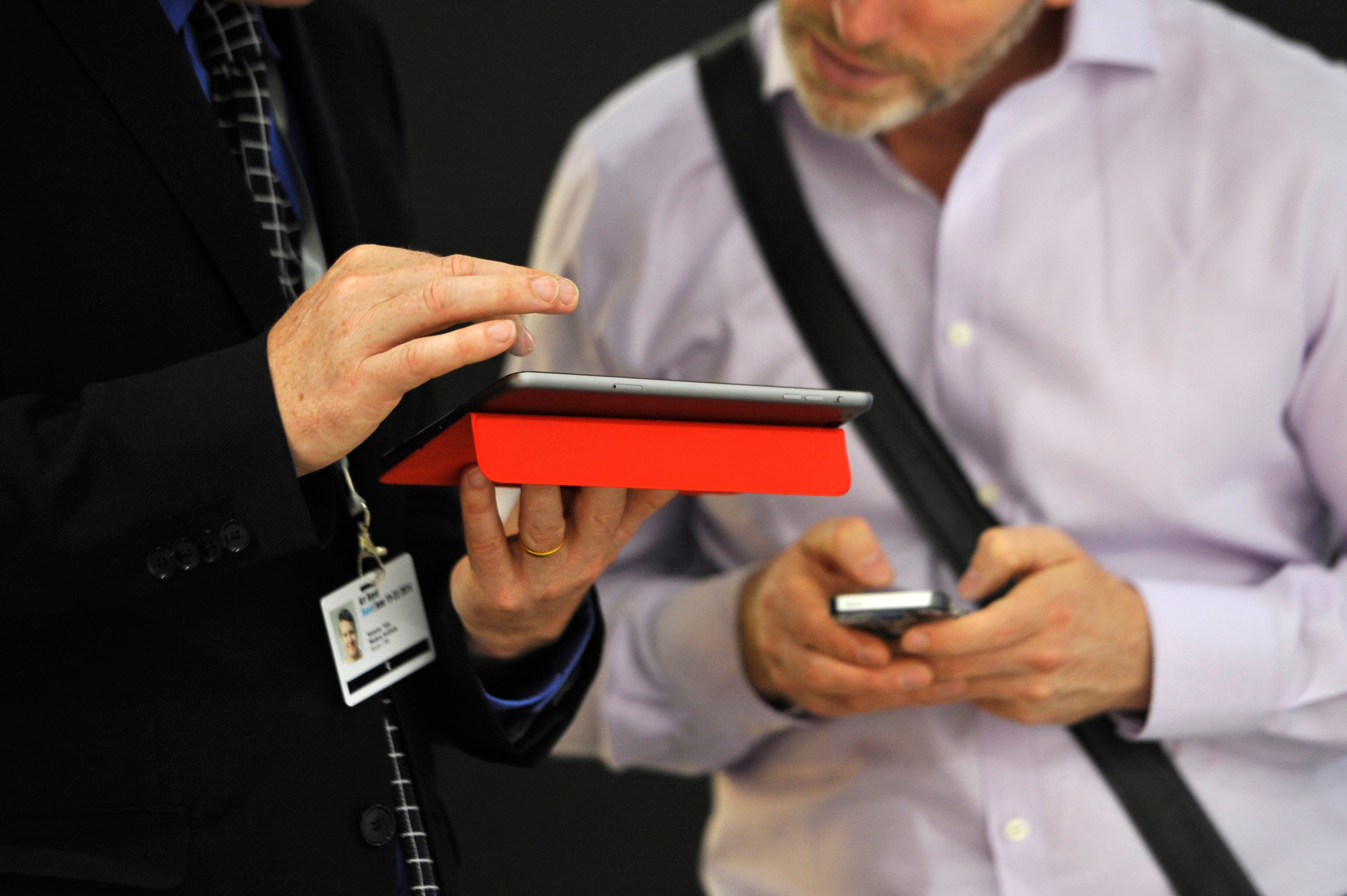 Visitors look at artworks in a catalog in the gallery section of Art Basel. Photo by Harold Cunningham/Getty Images.