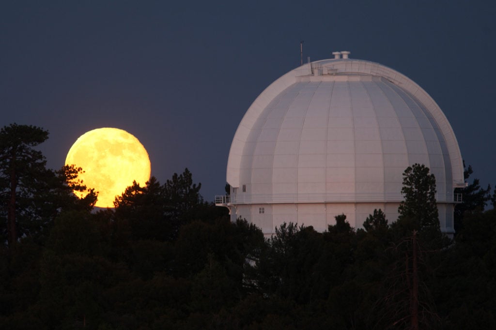 A Supermoon, or perigee moon, rises behind the historic Mount Wilson Observatory on July 12, 2014 at Mount Wilson in the Angeles National Forest northeast of Los Angeles, California. Photo by David McNew/Getty Images.