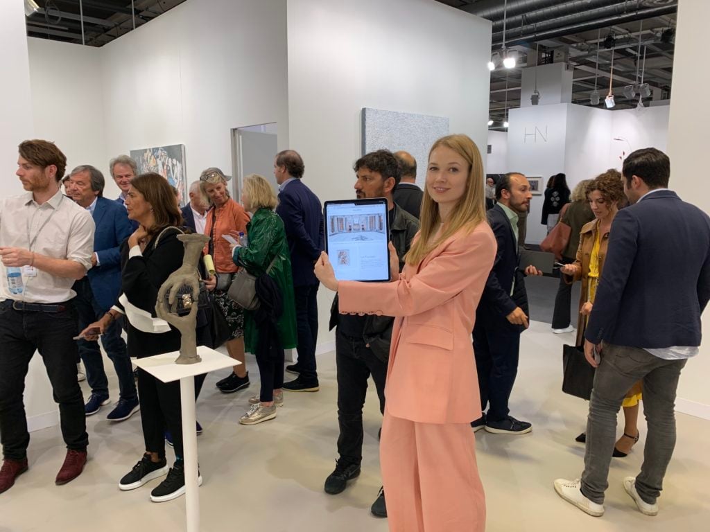 David Zwirner Online Sales Director Elena Soboleva with her iPad at the gallery's Art Basel booth back in 2019. Photo by Andrew Goldstein.