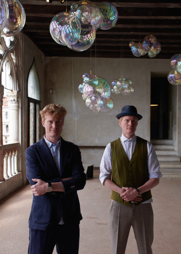 The Verhoeven Twins next to their installation, "Moments of Happiness", in Venice. Image courtesy Piaget. 