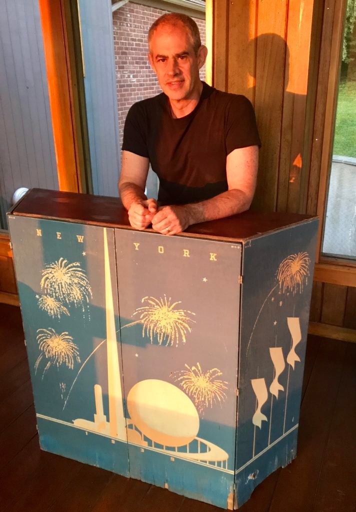 Dealer and collector Keith Sherman takes a seat behind an New York World's Fair information desk.
