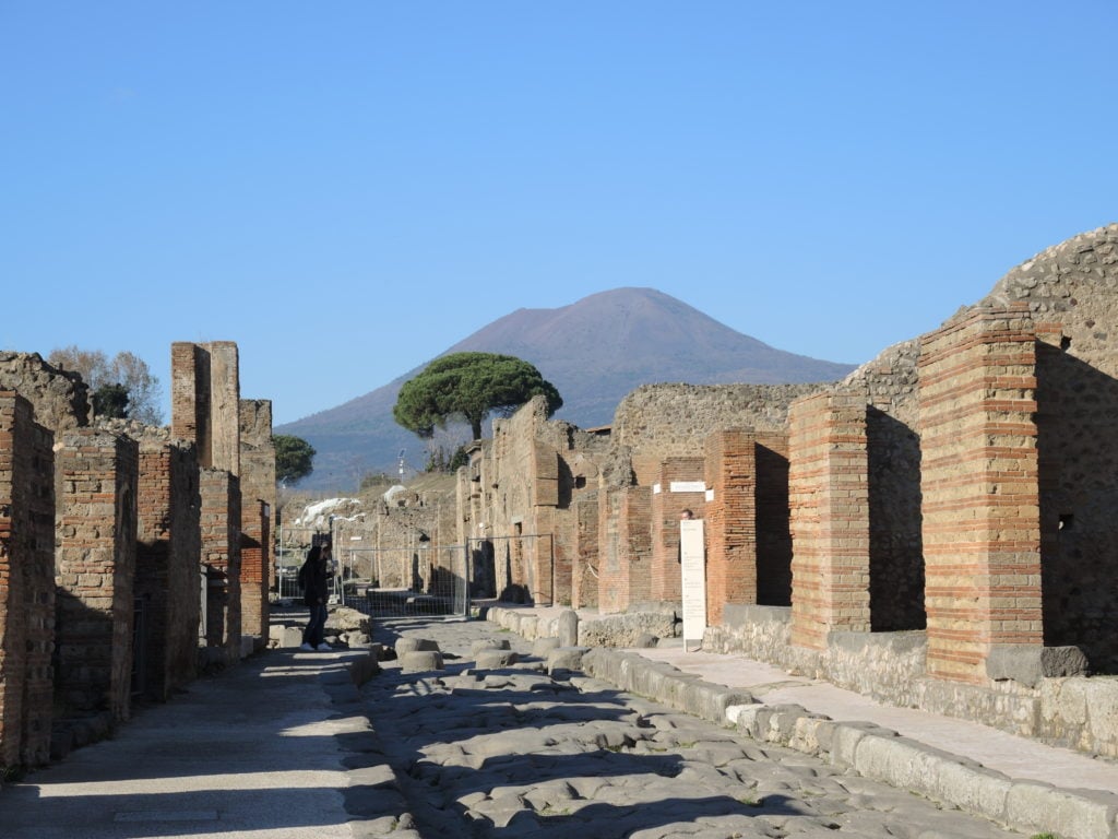 A road in the Pompeii Archaeological Park overlooking Vesuvius. The ancient city was buried during the eruption of Vesuvius in 79 A.D. and two thirds of it was excavated. The excavation site is one of the most popular sights in Italy. Photo by Lena Klimkeit/Getty Images.