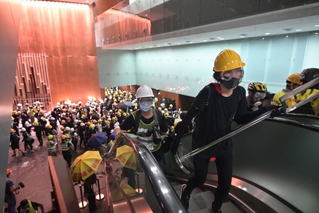 Protesters break into the government headquarters in Hong Kong on July 1, 2019, on the 22nd anniversary of the city's handover from Britain to China after successfully smashing their way through reinforced glass windows and prizing open metal shutters that were blocking their way. Photo: ANTHONY WALLACE/AFP/Getty Images