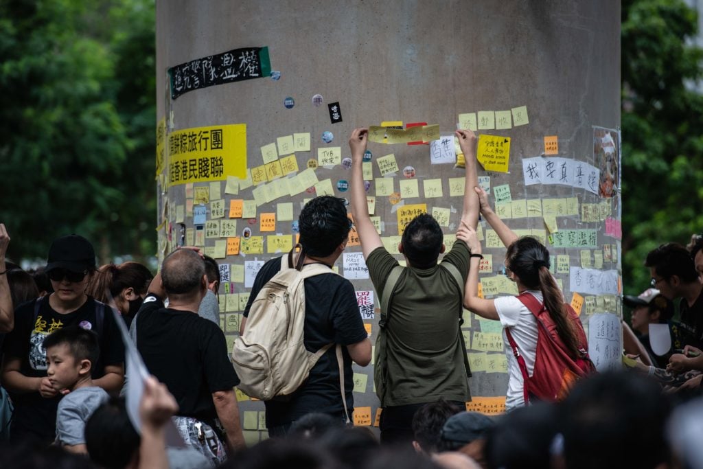 Demonstrators leave messages on sticky notes on a "Lennon wall" during the protests. (Photo by Ivan Abreu/SOPA Images/LightRocket via Getty Images)